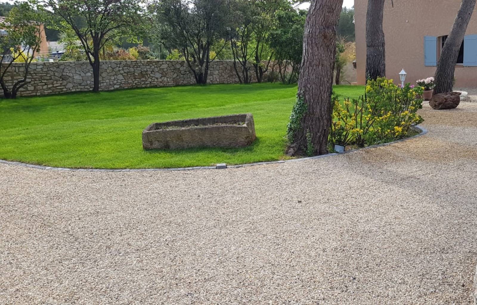 Photo d'une réalisation en gravier stabilisé gris avec contour en pavé et un aire de stationnement, parking en gravier stabilisé Alvéostar par Daniel Moquet Aix-en-Provence
