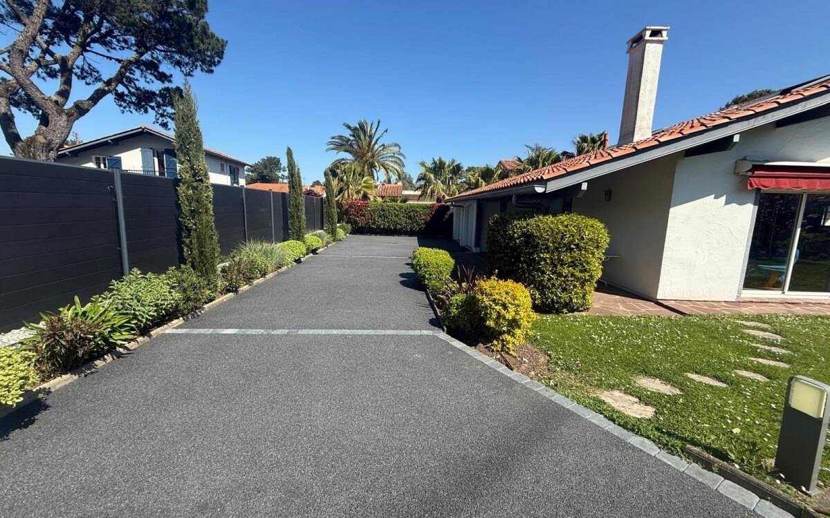 Photo d'aménagement d'une allée carrossable grise en Mineralstar, résine naturel et drainante pour exterieur avec pavé LaCouture en bordure, aménagement réalisé par Daniel Moquet Aix-en-Provence
