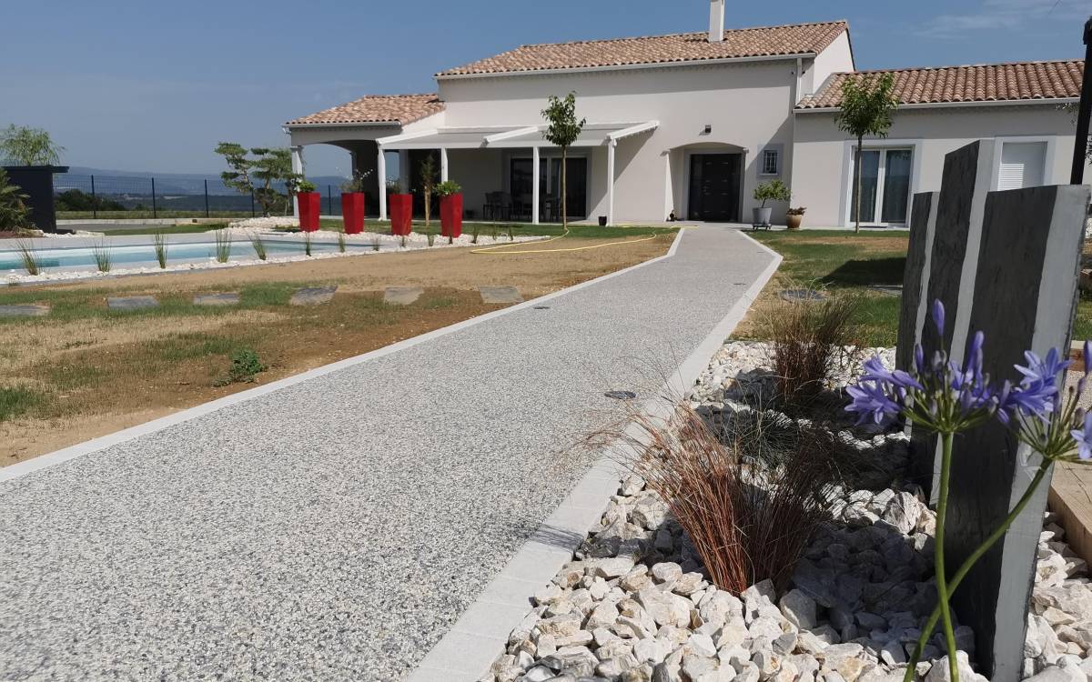 Image de réalisation d'un allée piétonne en resine drainante, moquette de pierre, hydrostar gris avec des bordure en pavé LaCouture pour un exterieur agréable par Daniel Moquet Aix-en-Provence