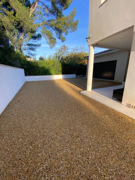 Aménagement exterieur jardin allée et aire de stationnement en pente avec un gravier stabilisé de Daniel Moquet Aix-en-Provence Alvéostar à Eguilles
