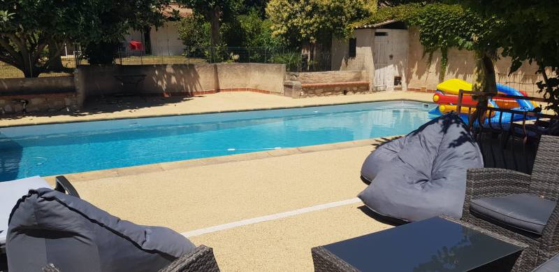 terrasse en Mineralstar avec son salon de jardin autour de la piscine 