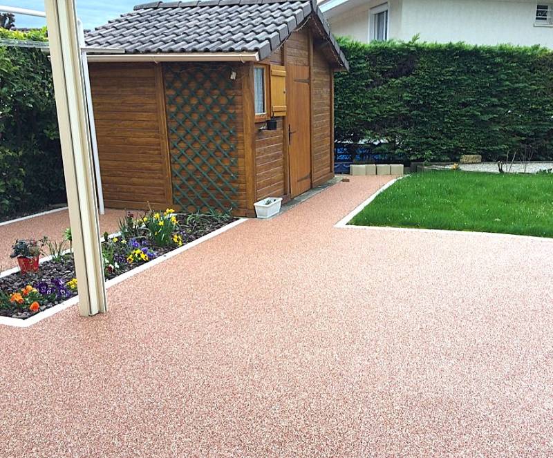 Réalisation d'un espace de vie avec une cour et terrasse autour d'un cabanon en harmonie avec la jardin avec cette résine drainante par Daniel Moquet Aix-en-Provence