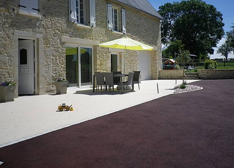 Photo de réalisation d'une cour avec terrasse en résine drainante beige ou moquette de pierre, Hydrostar et une seconde parti en gravier goudronné, Gravistar rouge par Daniel Moquet Aix-en-Provence