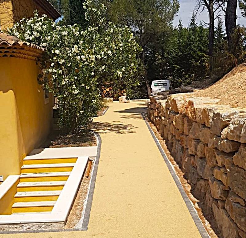 image d'un aménagement extérieur d'une allée pietonne et d'un esaclier en resine naturel drainante ou moquette de pierre signé Daniel Moquet allée à venelles