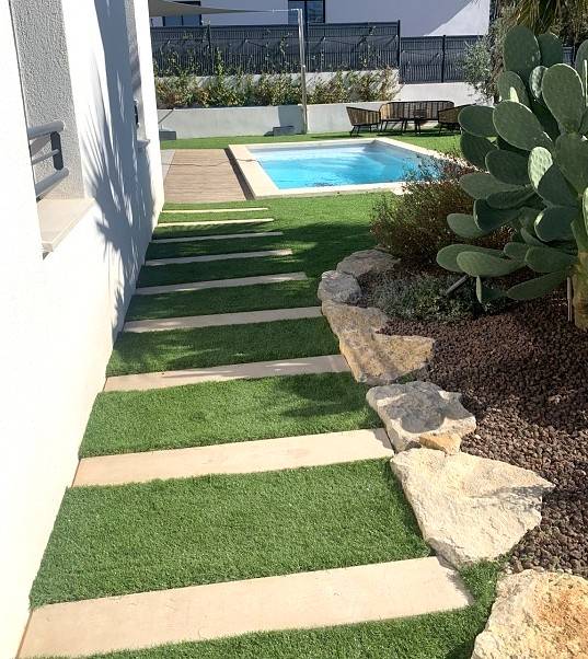 Aménagement d'une allée avec un espace vert en gazon synthétique, DM Green et en Boibé, béton effet bois par Daniel Moquet Aix-en-Provence