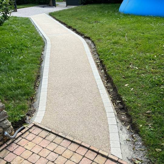 Photo de la réalisation d'une allée piétonne en resine naturelle drainante, Mineralstar® avec bordure en pavé LaCouture® par Daniel Moquet Aix-en-Provence