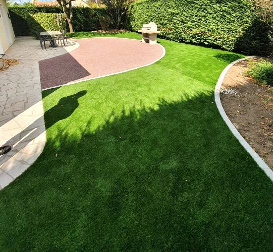 Photo de l'aménagement d'un jardin en gazon synthétique DM Green avec des accès en Gravistar par Daniel Moquet Aix-en-Provence